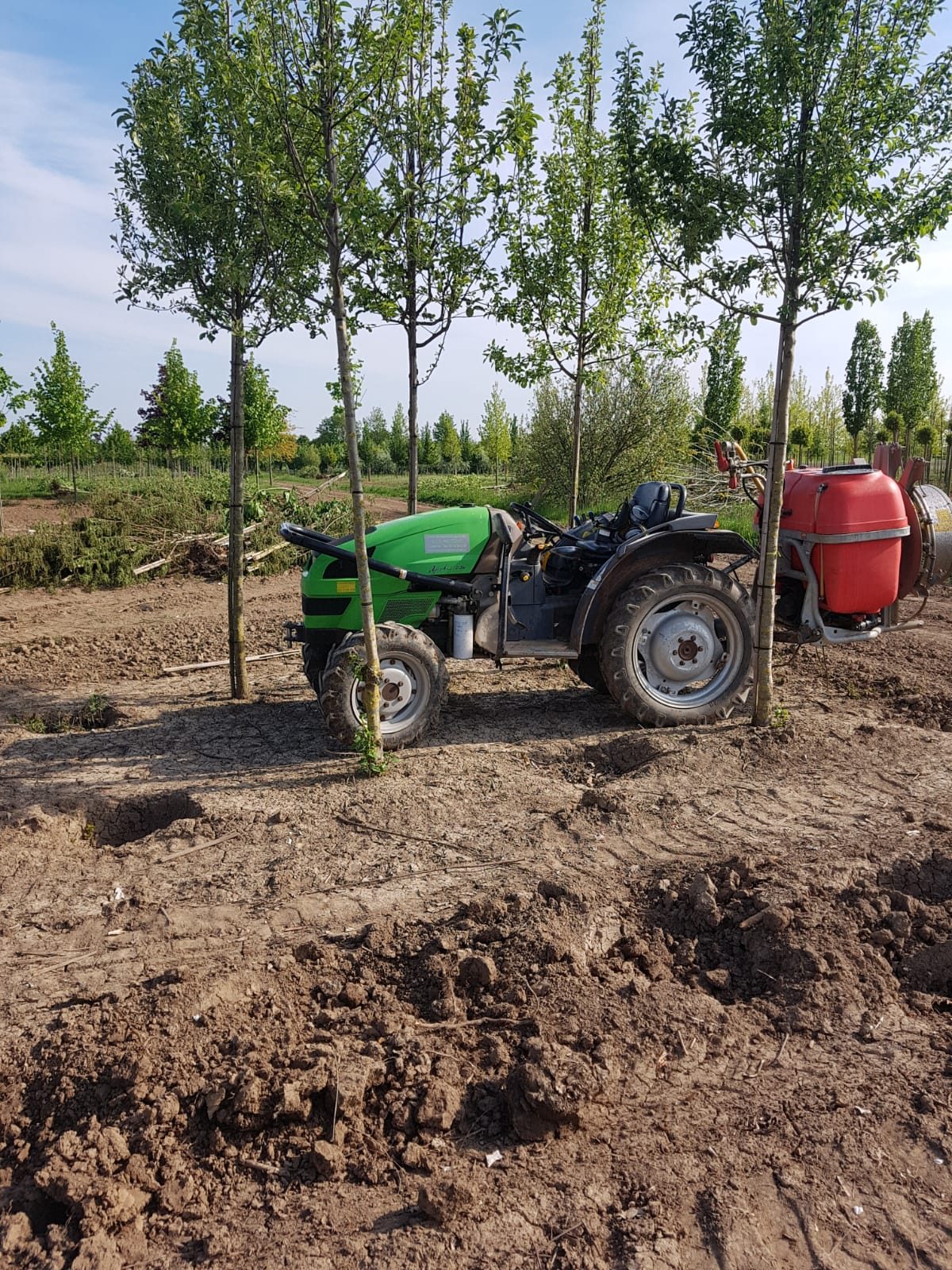 Onze trekker met blowerspuit in de boomkwekerij
