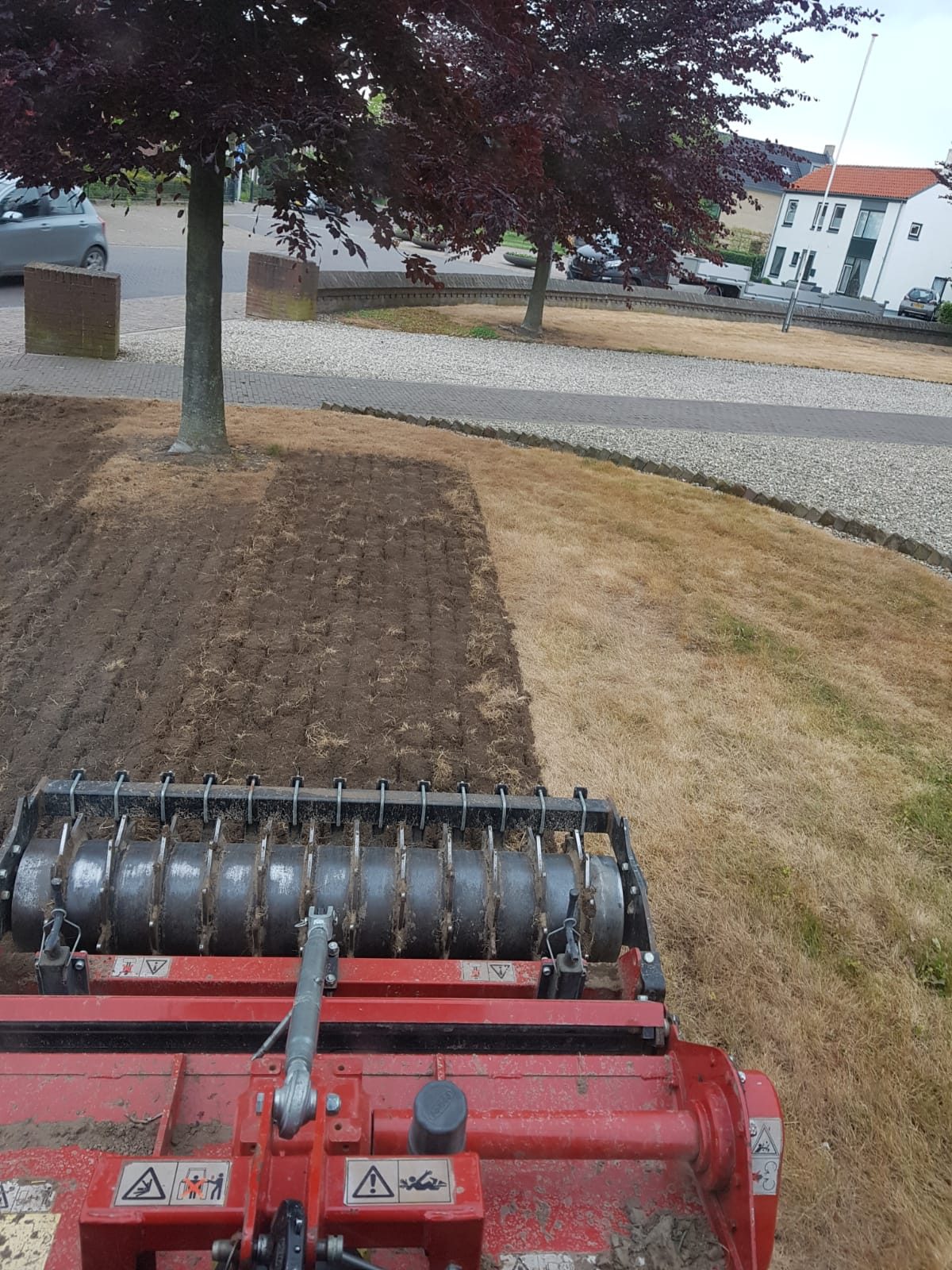 Een oude grasmat langs de straat onderfrezen met de overtopfrees